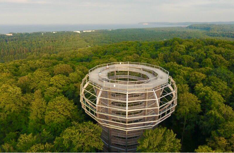 Aussichtsturm Adlerhorst des Baumwipfelpfads bei Prora, über grünem Wald mit der Ostsee im Hintergrund